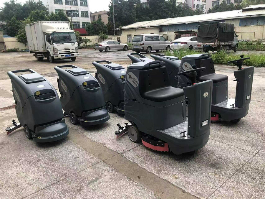 PADOM walk-behind and ride-on floor scrubbers arranged outdoors before delivery